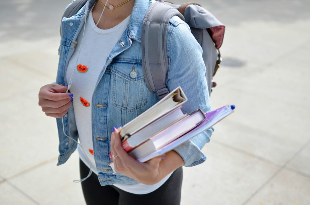 ragazza scuola superiore che porta dei libri in mano